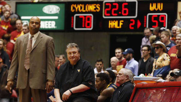 West Virginia assistant coach Erik Martin (left) and head coach Bob Huggins watch the final seconds of the game Saturday, Feb. 14, 2015, during the Cyclones 79-59 win over the Mountaineers at Hilton Coliseum in Ames. 0415 Isu Vs West Virginia27